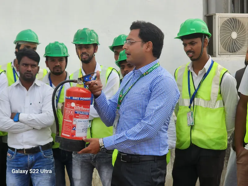 Trainer demonstrating a dry powder extinguisher
